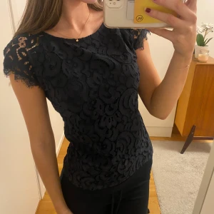 Mörkblå spetsblus från Kappahl  - Supersnygg mörkblå blus från Kappahl med detaljerad spets och korta ärmar. Transparent spets vid axlarna. Har sytt om den från L till ca xs💕