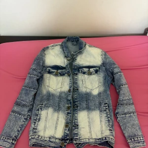 Slim fit jeansjacka från H&M - Snygg slim fit jeansjacka från H&M i tvättad blå och vit denim. Jackan har klassiska bröstfickor med knappar, långa ärmar och coola sömdetaljer. Perfekt för dig som gillar streetstyle och vill ha en jacka med attityd.