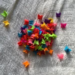 Butterfly clips-mix (nya)!💋 - Säljer ett gäng oanvända butterfly clips i massor av färger som röd, rosa, blå, lila, grön, gul och orange. För att de inte ska krossas eller få defekter har jag förvarat dem i en urdiskad plastburk som rymmer 300 g istället för påsen de kom i! De är supersöta men jag har som sagt aldrig använt dem!💋