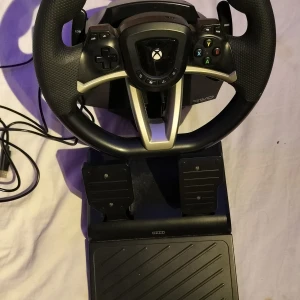 Xbox Racing Wheel med Pedaler - Komplett Xbox racingratt med pedaler, perfekt för bilspel. Ergonomiskt grepp, responsiva knappar och USB-anslutning. Passar utmärkt för racingupplevelser hemma. Produkten är använd minst 3-5 gånger 