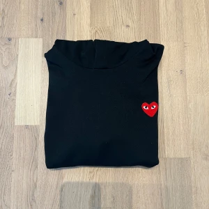 Play hoodie från Comme des Garçons - Säljer min svarta Play Hoddie från Comme des Garçons. Den är i storlek S och jag säljer den för att den blivit för liten. Skicket är mycket fint! Tveka inte på att höra av dig vid frågor😃 Bvsa