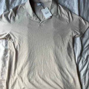 Beige pikétröja från These Glory Days - Snygg beige pikétröja från These Glory Days i storlek M. Tröjan har klassisk krage och korta ärmar, tillverkad i en mjuk blandning av linne och bomull. Perfekt för en clean och stilren look. Perfekt för dig som vill ha en stilren tröja fast med ett bra pris. Varan är helt ny. Nypris 700kr