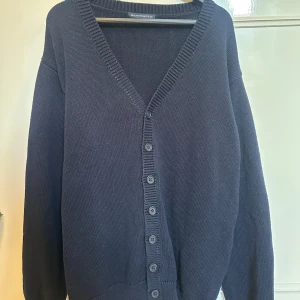 Mörkblå kofta från Brandy Melville - Mysig mörkblå kofta från Brandy Melville med djup v-ringning och knappar hela vägen framtill. Koftan är stickad och har långa ärmar samt breda ribbade muddar vid ärmslut och nederkant. Ganska stor i storleken, skulle säga att den passar s-xl beroende på vilken look man vill ha☺️Pris kan diskuteras. 