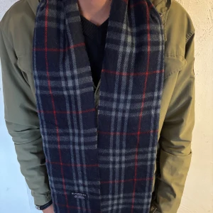 Rutig mörkblå kashmirhalsduk Burberry - Snygg halsduk från Burberry i mjuk kashmir. Perfekt nu inför kyligare dagar. Mycket bra skick, bara att skriva vid frågor eller funderingar.