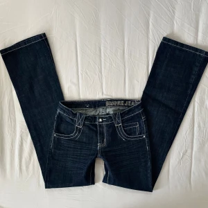 Mörkblå vintage lågmidjade jeans - Mörkblåa jeans från B.more med vita sömmar, strl S // midja 37cm tvärsöver, innerbenslängd 84cm  