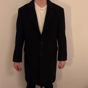 Svart rock från Park Lane, storlek 48 - Svart rock från Park Lane i klassisk modell med två knappar framtill och diskreta fickor. Snygg krage och rak passform som ger en clean och stilren look. Perfekt för dig som vill ha en enkel och tidlös jacka till höst och vinter. ALDRIG ANVÄND och PRIS KAN DISKUTERAS nypris:5 999