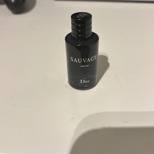 Dior Sauvage Parfum 10ml - Snygg och smidig flaska med Dior Sauvage Parfum, perfekt storlek för att ta med överallt. Volymen är 10 ml och den är tillverkad i Frankrike. En ikonisk parfym från Dior som ger en exklusiv känsla. Det är för ”duttning” alltså ingen spray. Köpte ny för 400kr, säljer för 100kr. Den är inte använd.