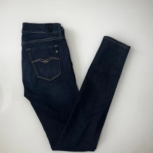 Replay New Luz Jeans - Snygga mörkblå jeans från Replay med klassisk femficksdesign och kontrastsömmar. Byxorna har en rak passform och är tillverkade i slitstarkt denimtyg. Perfekta för dig som gillar stilrena och tidlösa jeans med diskreta detaljer.