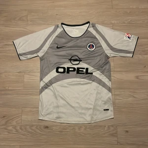 PSG Ronaldinho 01/02 - Säljer en PSG bortatröja från säsongen 01/02 med Ronaldinho och nummer 21 på ryggen. Storlek M. Tröjan är i nyskick och har inte använts sedan köpet