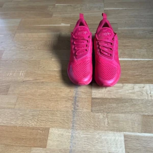 Nike Air Max 270 helröda sneakers - Säljer ett par Nike Air Max 270 sneakers i helrött. Skorna har en luftig mesh-överdel, synlig Air Max-dämpning i hälen och klassisk snörning. Perfekta för dig som vill sticka ut med en färgstark look. Storlek EU 44.5