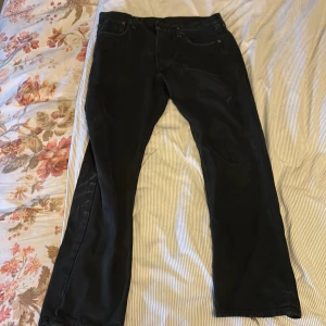 Svarta Levi's 501 jeans W32 L30 - Svarta Levi's Premium 501 jeans med klassisk rak passform. Jeansen har fem fickor, knappgylf och är tillverkade i slitstarkt bomullstyg. Perfekta för dig som gillar en tidlös och clean look.