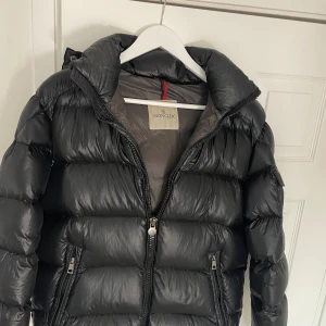 Moncler Maya jacka  - Säljer denna Moncler jackan i modellen Maya. Den är i storlek 1 och passar allt från S-L beroende på hur man vill att den ska sitta. Den är äkta, taggen finns kvar och kan även skicka äktighetsbevis med bild på NFC scan, det är bara att skriva! Den har inga defekter såsom hål t.ex, men den är lite sliten pga att den köptes för ca 3 år sedan. Hör av er om ni vill köpa! Pris kan diskuteras