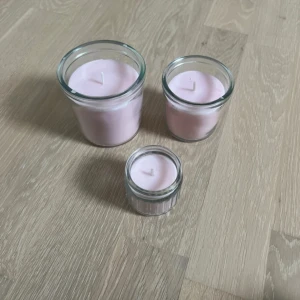 IKEA rosa doftljus i glas, 3-pack - Säljer tre rosa doftljus från IKEA i glasbehållare. Ljusen är oanvända och har en brinntid på upp till 40 timmar. Perfekt för att skapa mysig stämning hemma. Glasen är hela och ljusen ser ut som nya utan synligt slitage eller defekter.