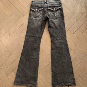 Grå lågmidjade, bootcut jeans från Gina Tricot - Jättesnygga lågmidjade, bootcut jeans med broderade bakfickor från Gina Tricot. Jag säljer för 250kr + frakt som kunden betalar, pris kan diskuteras.