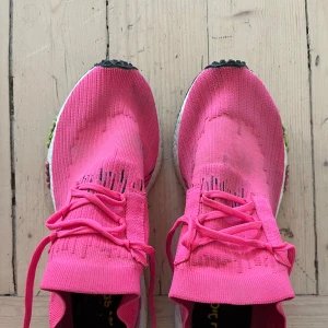 Adidas rosa. Adidas NMD, Racer Primekit, Running shows, Mens US 8,5, stl 42. Solar Pink, Boost CQ2442. - Säljer ett par Adidas sneakers i stark rosa färg med stickad ovandel och svarta detaljer. Skorna har snörning, vit platt sula med boost-teknologi och svarta dragflikar bak. Snygga stripes på sidan och coola grafiska inslag. Perfekta för dig som gillar att sticka ut.