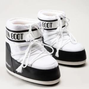 Svarta och vita Moon Boots - Moon Boots i svart strl 39~41 och vitt med rund tå och platt sula. Skorna har snörning framtill och bred logotypdetalj runt skaftet. Tillverkade i syntetmaterial med robust design, perfekta för kalla vinterdagar. 