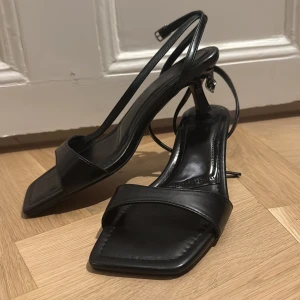 Klackar  - Svarta klackar med öppen tå, super fina och aldrig anväda! Ungefär 2cm klass storlek 38