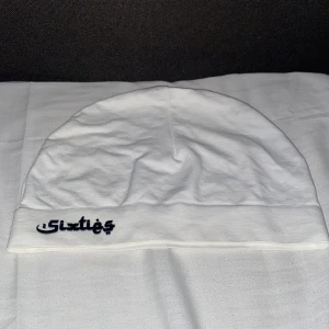 Vit mössa från Sixties - Vit mössa från Sixties med svart logotyp framtill. Enkel och clean design med mjukt material och bred kant nedtill. Perfekt för dig som gillar stilrena accessoarer och vill ha något som funkar till de flesta outfits.