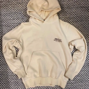 Beige hoodie från Jack & Jones Originals - Snygg beige hoodie från Jack & Jones Originals med stor brunt tryck på ryggen och mindre tryck på bröstet. Klassisk känguruficka framtill och huva. Perfekt för chill dagar och streetstyle. Mjuk bomullskvalitet och normal passform. Passar folk som är 155-170cm långa.