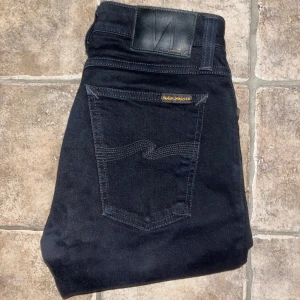 Nudie jeans  - Snygga svarta skinny jeans från Nudie Jeans i modellen Skinny Lin. Jeansen är tillverkade av ekologisk bomull med lite stretch för extra komfort. Klassisk femficksdesign och svarta sömmar ger en clean look. Ifall det inte finns någon bild i annonsen där jag bär plagget så är det för att jag ej kan ha storleken heller passformen, så kolla måtten för storlek och googla på modellnamnet för passform 😉S4