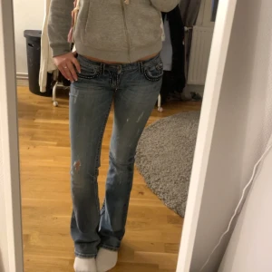 Miss Me blå bootcut jeans med broderi - Snygga blå jeans från Miss Me med bootcut passform och låg midja. Jeansen har coola broderade detaljer och kontrastsömmar på bakfickorna, samt slitningar för en trendig look. Perfekta för dig som gillar statement-jeans med unik design. Köpte för 900 kr och har varit väldigt sparsamt använda 💞💞