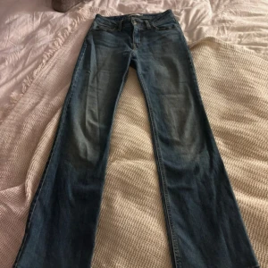 Levi's Superlow Boot jeans blå 26 - Snygga blå Levi's Superlow Boot jeans i klassisk bootcut-modell med låg midja. Jättefina! Perfekt för dig som gillar retrovibbar och avslappnad stil.