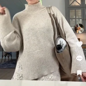 Beige stickad polotröja med ribbad kant - Säljer en beige stickad polotröja med bred ribbad kant nedtill och vid halsen. Tröjan har lång ärm och en loose passform som ger en chill och avslappnad vibe. Perfekt för lager-på-lager och passar snyggt till både jeans och kjol.