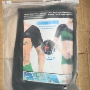Shoulder Support Brace Universal Size - Axelstöd med justerbar ärm och tryckplatta. Designad för dislokationer, AC-ledstukningar, labrumskador, axelsmärta och axelinflammation. Axelkompressionsärm. Universal storlek, passar både höger och vänster axel, för män och kvinnor. 1 st. Ny axelstöd med justerbar ärm och tryckkudde, universal storlek för både män och kvinnor. Passar höger och vänster axel, idealisk vid smärta, skador eller rehabilitering. Produkten är obruten i originalförpackning och ser oanvänd ut.