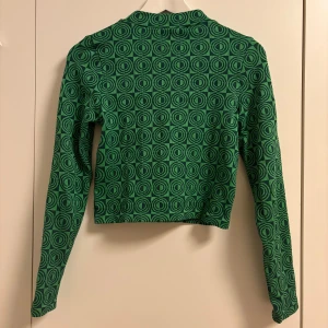 Grönmönstrad långärmad tröja  - Grönmönstrad långärmad tröja i ljus/mörkgrön, sällan använd och i mycket bra skick, superskön och stretchig, storlek M men passar mellan S-L