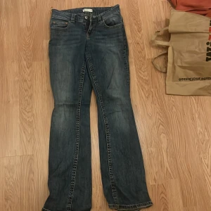 Blå bootcut jeans från Perfect Jeans - Snygga blå jeans från Perfect Jeans i klassisk bootcut-modell. Jeansen har fem fickor, dragkedja och knapp framtill samt coola bakfickor med lock och knapp. Materialet är slitstarkt denim och passformen är normal med lätt utsvängda ben. Helt nya och använts 1 gång.