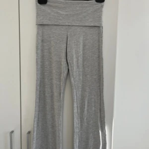 Grå lågmudjade yoga pants - Superbekväma grå yoga pants med låg midja. Perfekta för chill dagar eller när du vill ha något riktigt mjukt och skönt på dig. Tillverkade i ett stretchigt och mjukt material som känns lätt mot huden. Dem är i storlek 170 men är som XS. Pris går såklart att diskutera.