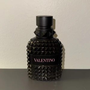 Valentino Born in Roma Uomo Edt 50 ml - Snygg parfym från Valentino i en mörk, nitar-inspirerad flaska. Perfekt för dig som vill sticka ut och addera en lyxig touch till din stil. Märket är känt för sin trendiga och exklusiva känsla. Cirka 35 till 40 ml återstår i flaskan :)