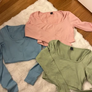 Ribbad croppad topp i pastellfärger storlek M - Tre croppade långärmade toppar från Shein i pastellblått, ljusgrönt och ljusrosa. Alla har fyrkantig urringning och är ribbade i mjuk bomullsmix. Perfekt för dig som gillar stilrena och trendiga basplagg med en twist.