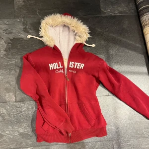 Hollister fur hoodie - Fur Hoodie från Hollister. I använt skick, köpt på loppis. Liten i storlek, står XXL men skulle säga M-L. Lite missfärgad foder inuti pågrund av röd och vit tvätt. Och nån mindre synlig fläck fram (sista bild) lite dålig bild med min skugga ivägen också. Pris går att diskutera