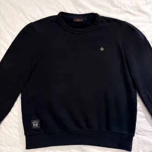 Morris sweatshirt - En stilren mörkblå sweatshirt från Morris med rund halsringning och diskret broderad logga på bröstet. Tröjan har ribbade muddar och en patch nertill. Priset är ej hugget i sten!