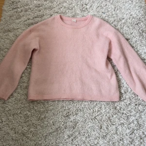 Ljusrosa stickad tröja ARKET barn - Supermjuk och basic ljusrosa stickad tröja från Arket. Tröjan har rund halsringning, ribbade muddar och lång ärm. Perfekt för lager på lager under höst och vinter. Enkel att matcha med jeans eller kjol. Helt otrolig kvalitet!! Inga som helst tecken på användning även om jag har haft den i några år!!!