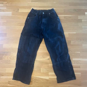 Svarta baggy jeans från District Fortysix - Säljer ett par svarta jeans från District Fortysix i storlek S. De är väl använda och har små defekter (se bild) men annars är dem bra. Vid eventuella frågor är det bara att höra av sig!