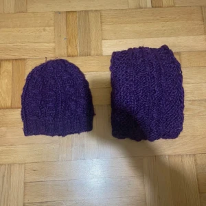 Lila stickad mössa från H&M - Säljer en lila stickad mössa från H&M i chunky garn med kabelstickat mönster. Mössan är tillverkad i en mjuk blandning av 85% akryl och 15% ull, perfekt för kalla dagar. Snygg och enkel att matcha med vinterjackan.