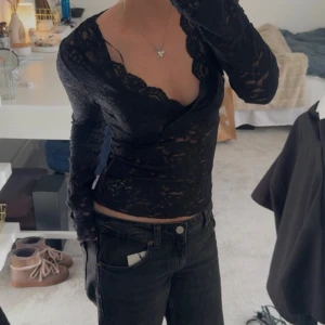 Svart spetsblus med omlott och v-ringning - Har använts en gång och är i jätte bra skick! 💕