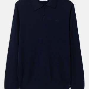 Mörkblå pikétröja från J.Lindeberg - Snygg mörkblå långärmad pikétröja från J.Lindeberg. Tröjan har klassisk krage, knäppning framtill och är tillverkad i mjuk bomull. Perfekt för dig som gillar stilrena och tidlösa plagg med en clean look.