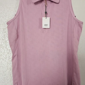 Ljusrosa ärmlös pikétopp från CRW - Säljer en ljusrosa ärmlös pikétopp från CRW i storlek XL. Toppen har klassisk krage och dragkedja framtill. Materialet är lätt och andas, perfekt för varma dagar eller till ridning. Enkel och stilren design som är lätt att matcha.