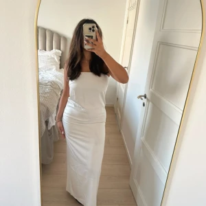 Bandå klänning  - Vit Bandå klänning i storlek 38 från Gina Tricot, den har slits bakom samt en dragkedja på sidan! Har används en gång men har fått nått märke på framsidan av klänningen som jag visar på den sista bilen syns inte jätte tydligt!  Jag finns tillgänglig i Skövde, Borås & Värnamo om ni vill skippa frakten🥰🤗