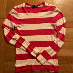 Randig långärmad tröja Ralph Lauren - Säljer en snygg långärmad tröja från Ralph Lauren i rött och vitt med breda ränder i storlek S. I riktigt bra skick, är öppen för förhandling.