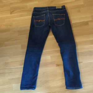 Nudie Jeans Grim tim, storlek 32/32 - Snygga Nudie jeans i modellen Grim tim och storleken 32/32. De är i fint skick och har en snygg fade. 