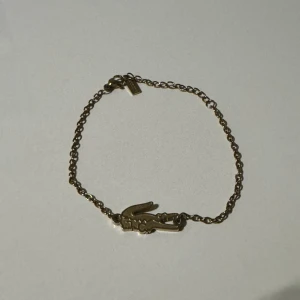 Lacoste armband för tjejer - Snyggt guldigt armband från Lacoste. Unikt att bära på som tjej 