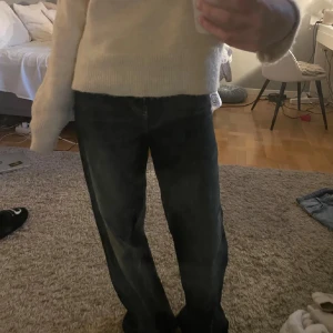 Mörkblå wide jeans från Bershka  - Säljer ett par mörkblå jeans från Bershka  med breda ben och klassisk femficksdesign. Jeansen har låg midja och är tillverkade i ett slitstarkt denimtyg med snygga tvättade detaljer. Perfekt för dig som gillar en avslappnad och trendig look.