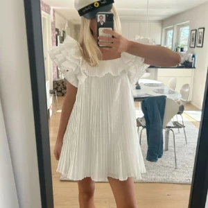 Vit plisserad volangklänning - Säljer denna så sjukt fina och eftertraktade klänningen från Zara, såååå fin till studenten!! 💓💓💓Kom med prisförslag!! 🙏🏼💓 