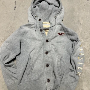 Vintage Hollister hoodie med knappar - Extremt eftertraktad och sällsynt vintage  Hollister hoodie med knappar! Grymt skick, inga defekter - ser exakt ut som på bild! Storlek L passar M med!. Skriv vid frågor!💬
