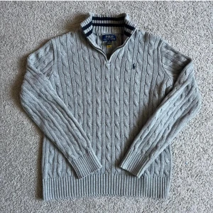 Polo Ralph Lauren kabelstickad halfzip 14-16 - Säljer en stilren grå kabelstickad tröja från Polo Ralph Lauren. Den är i storleken 14-16 år och passar perfekt nu mot de kallare dagarna. Tveka inte att skriva om du har några frågor eller funderingar, Priset går även att diskutera!