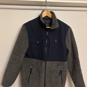 Ralph lauren fleecejacka - Grå och blå ralph lauren fleecejacka i storlek S. helt oanvänd. Skriv vid frågor.